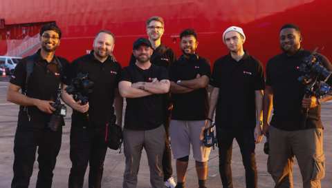 The Incite Video crew with their camera kit in front of a ship on location