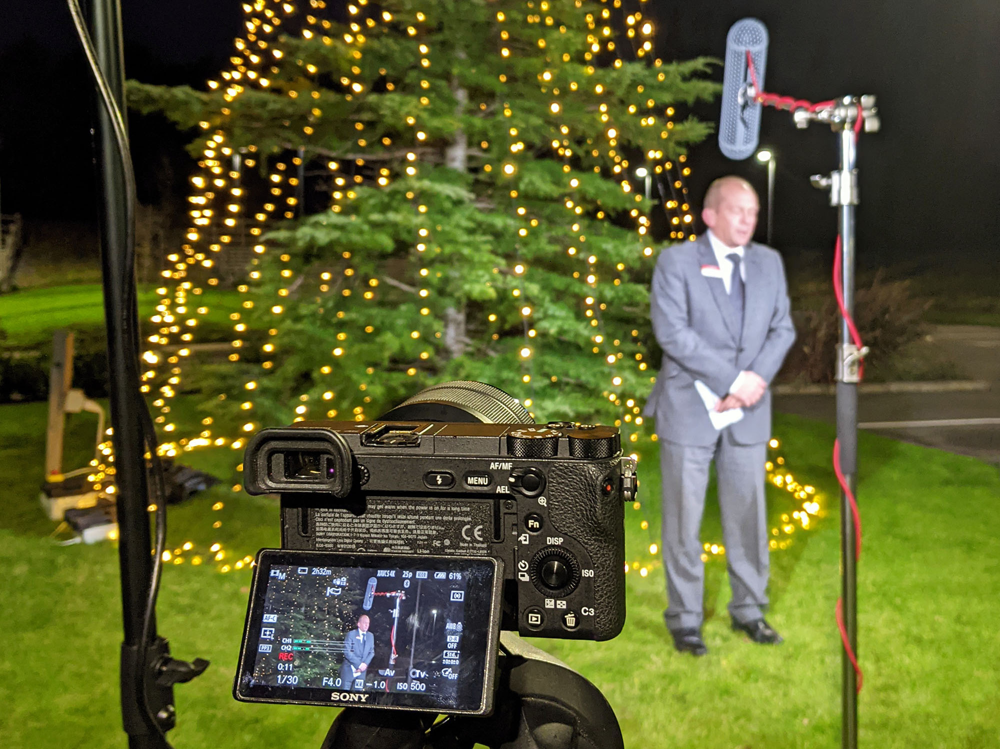 A behind the scenes shot of a lit up Christmas tree