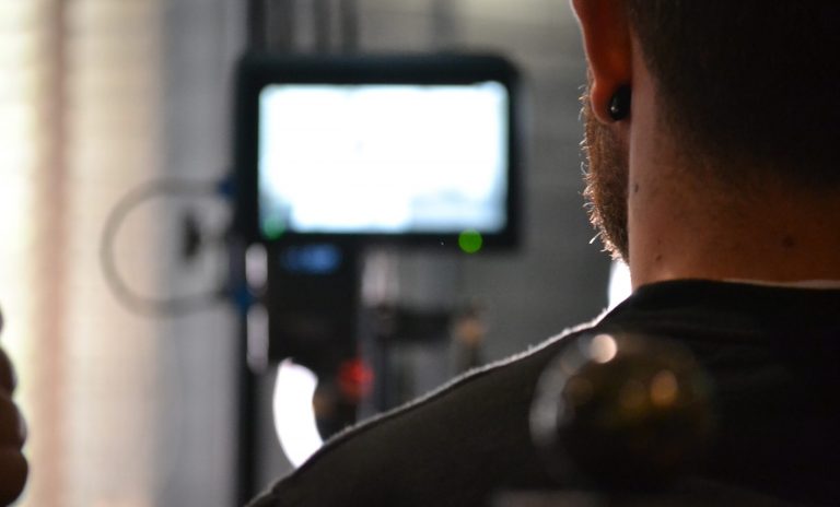 A behind the scenes images showing a member of the Incite team filming on set