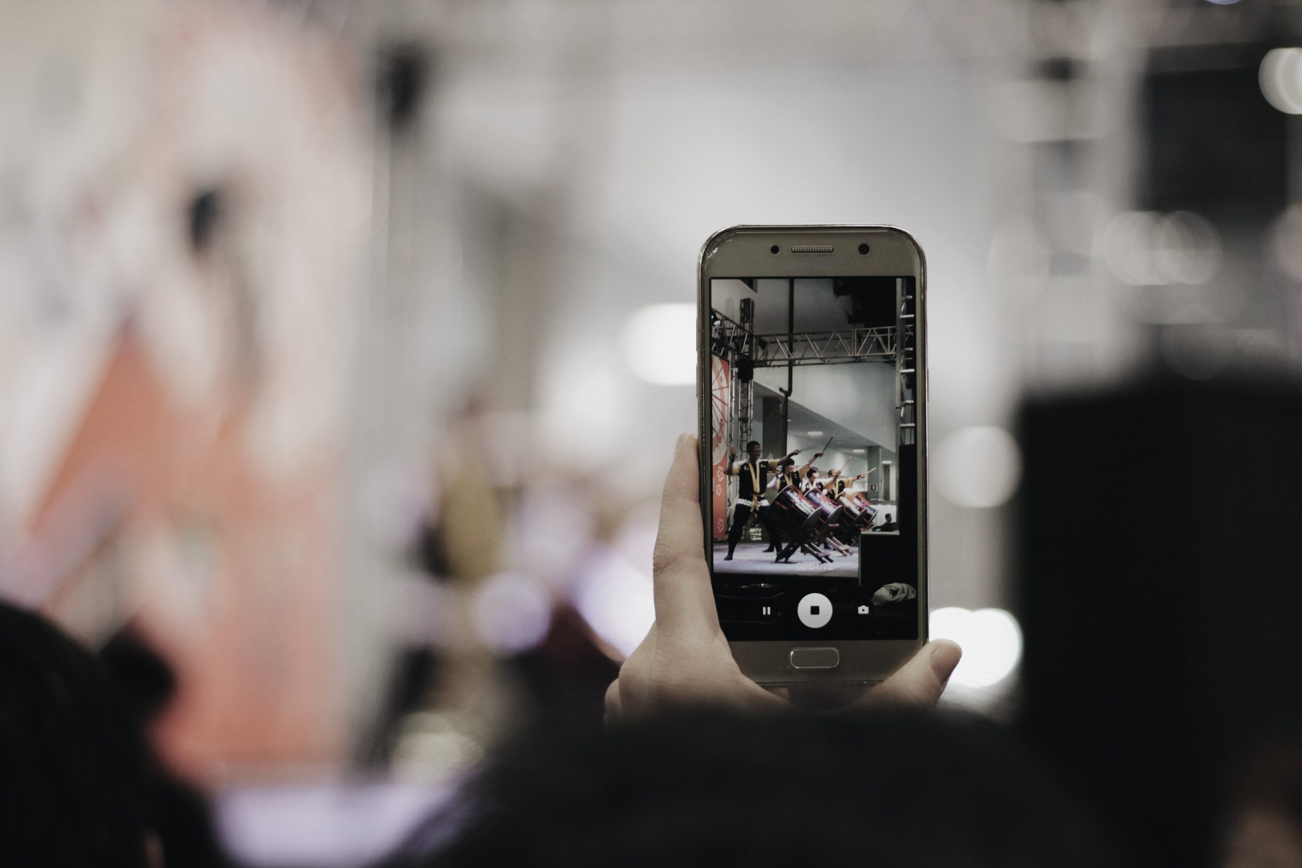 Image shows someone filming a crowdfunding video on their mobile phone.