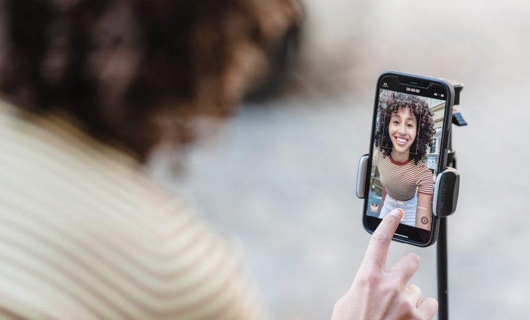 Image shows a woman recording a crowdfunding video on her mobile phone.