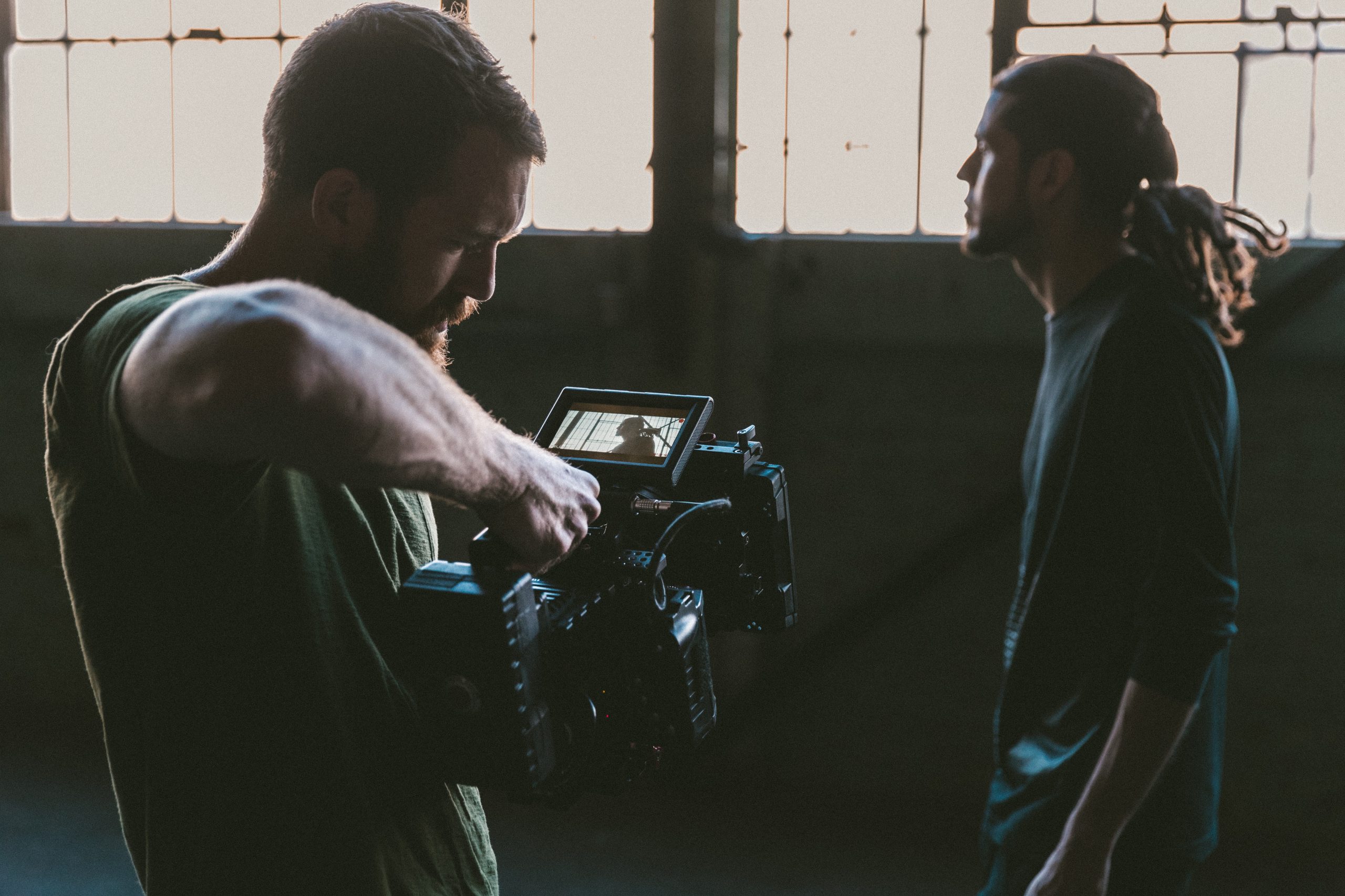 Image shows one man filming another, behind the scenes imagery from a video shoot.