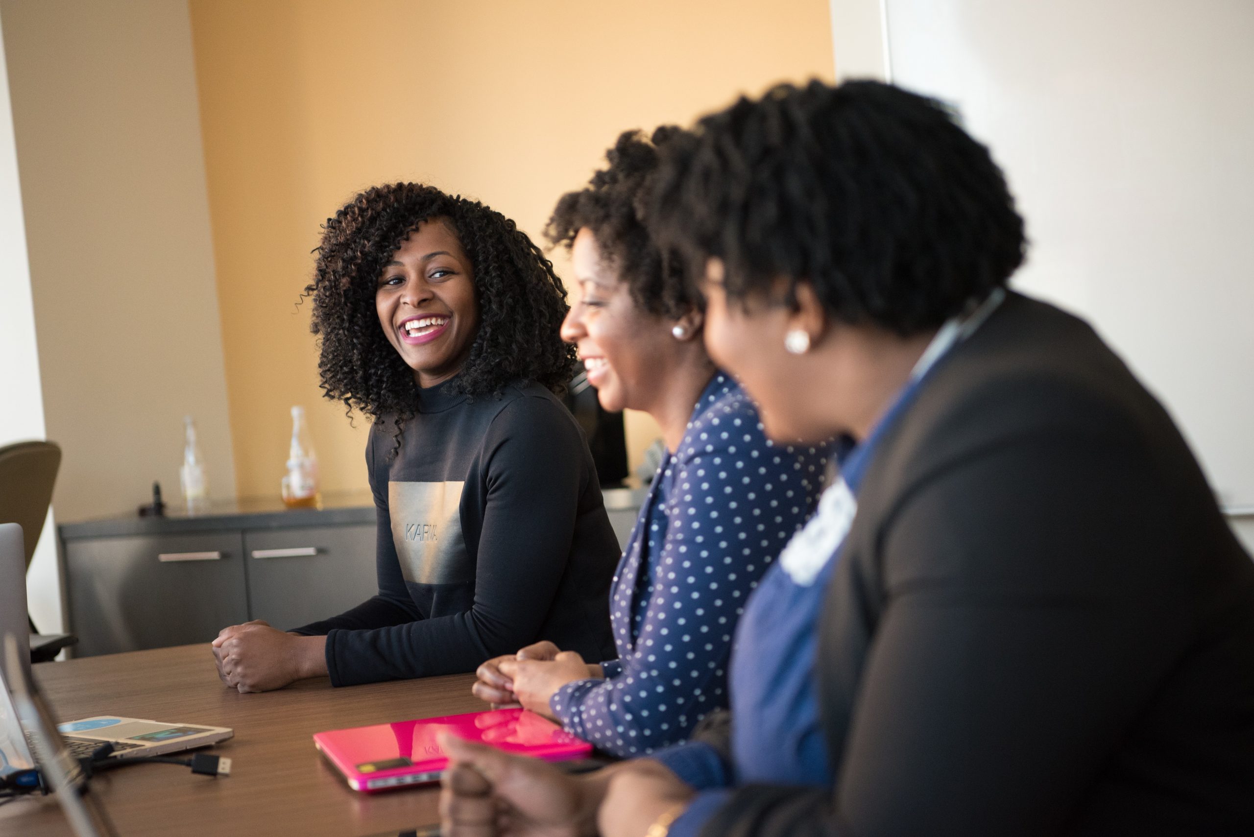 Image shows three women at work watching an instructional video